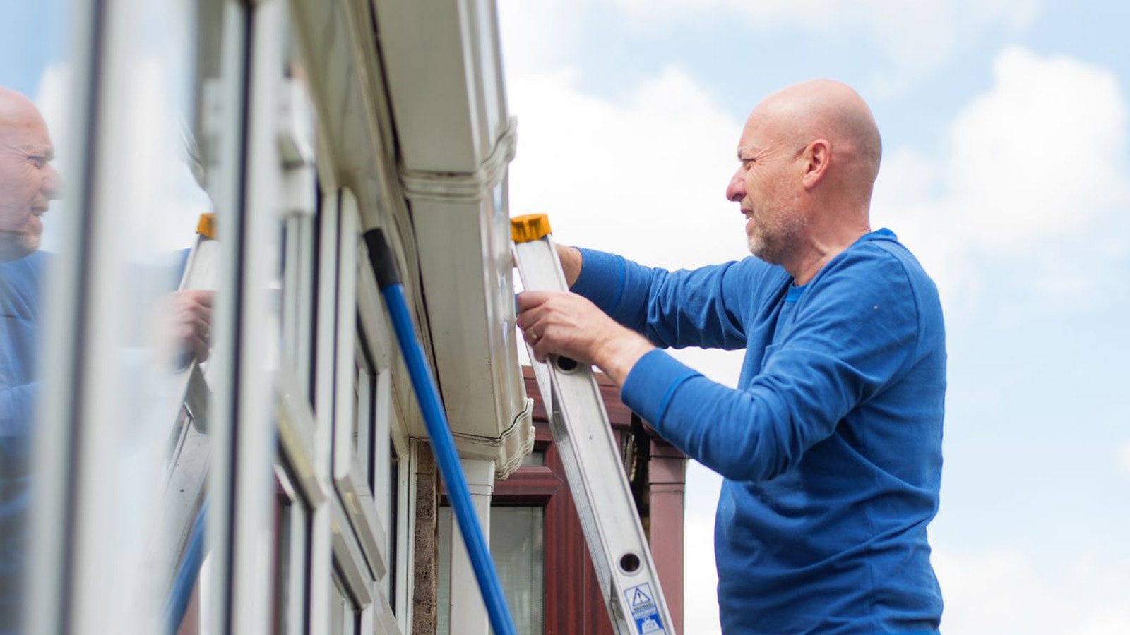 Energitjek med Sparekassen Thy Mand på stige ved hus