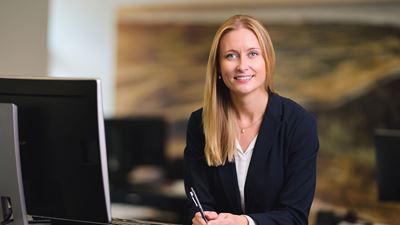 En kvindelig medarbejder står ved sit skrivebord