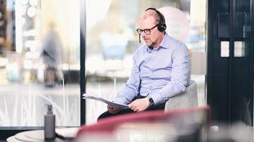 Mand taler i telefon mens han kigger på papirer