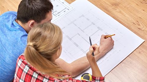 Kvinde og mand fordybet over arbejdstegninger