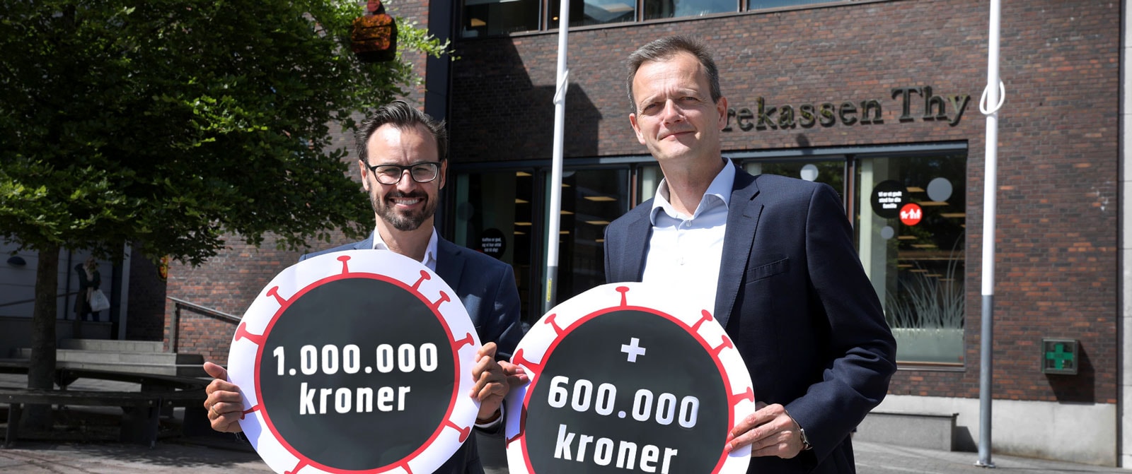 to forretningsfolk med skilte corona foran pengeinstitut