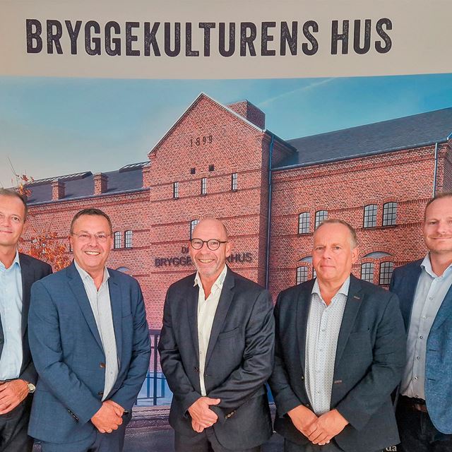Direktørerne for Sparekassen Thy, Thy-Mors Energi, Thisted Bryghus og Thisted Forsikring foran en visualisering af det nye Bryggekulturens Hus