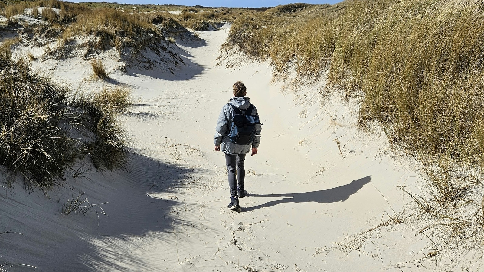 Ældre dame går på stranden
